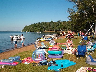 People at the beach at Evergreen Lodge on Woman Lake Longgille Minnesota